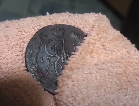 Протирання мідної монети після чищення